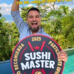 Tulio Recomienda sosteniendo un letrero de agradecimiento por los más de 100.000 rollos del Sushi Master 2025.