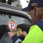 Carro mal parqueado en Bogotá con sticker "Pillado mal parqueado"